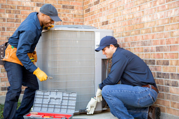 Climatisation Multi-ethnic team of blue collar air conditioner repairmen at work. They prepare to begin work by gathering appropriate tools from their tool box.